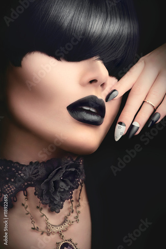 Fashion model girl with black gothic hairstyle, makeup, manicure and accessories