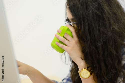 Young businesswoman on a coffee break. Using computer.