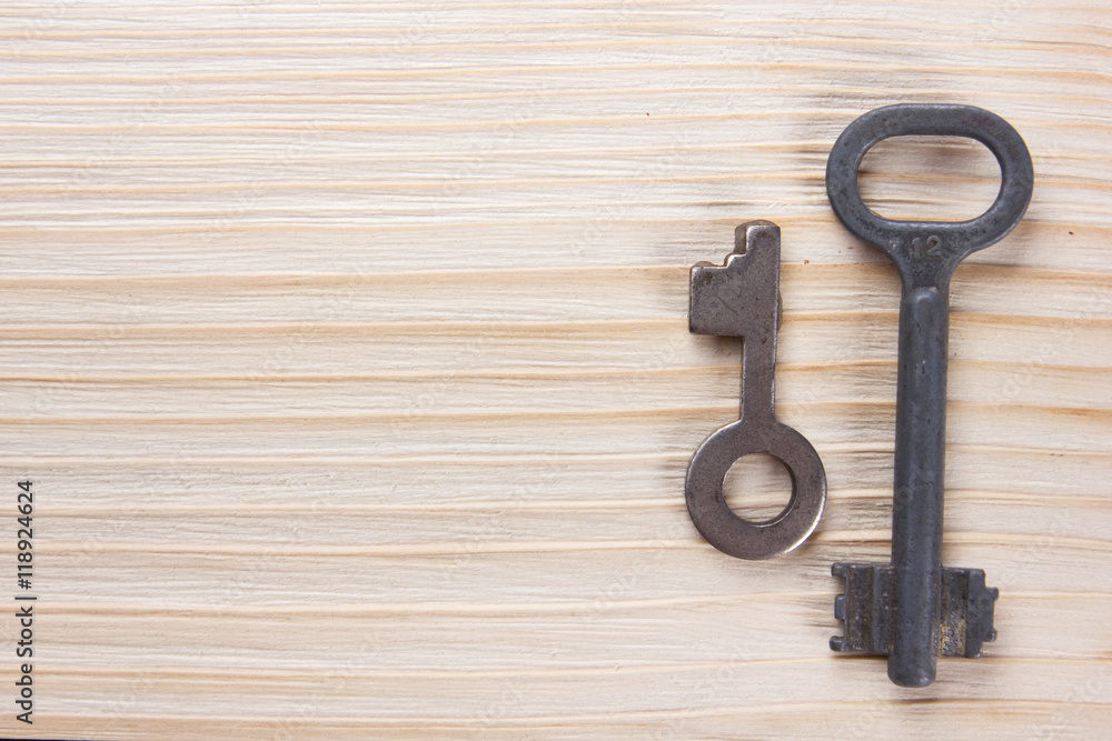 Real estate concept. Silver key with copy space for ad text and blank business note pad on wooden background. Top view. Real estate concept. Silver key with copy space for ad text and blank business note pad on wooden background. Top view.