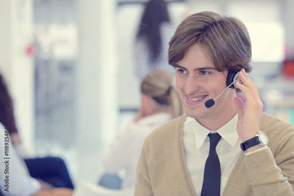 Smiling young call center executive at startup office Smiling young call center executive at startup office