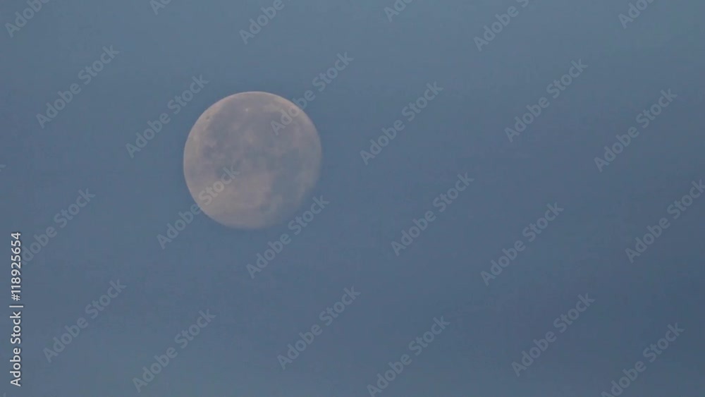The full Moon is moving through the cloudy night sky