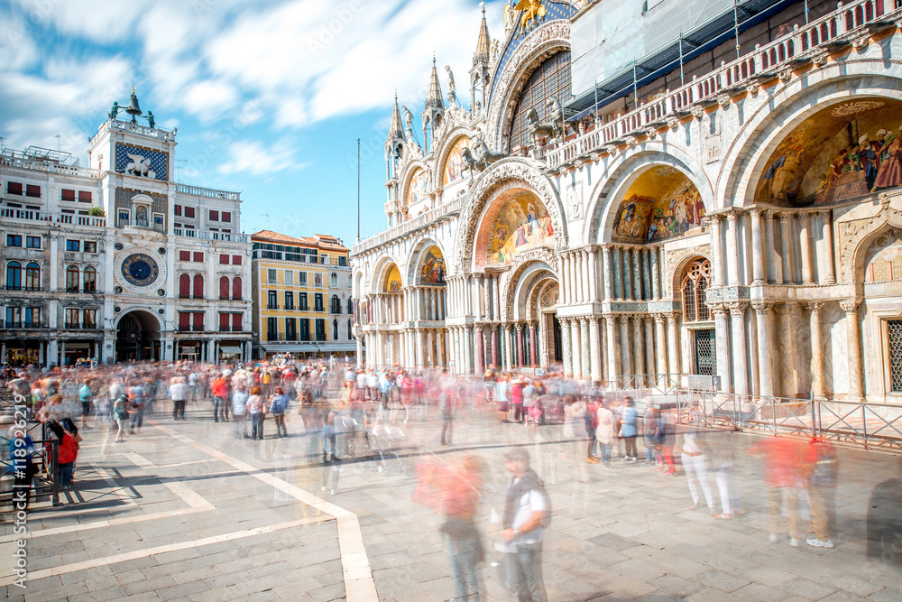 Obraz premium Saint Mark's square with basilica and clocktower in Venice. Long exposure image technic with motion blurred people