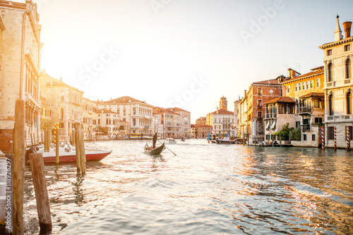 Venice cityscape view on Grand canal with colorful buildings and gondola floating on the sunset © rh2010