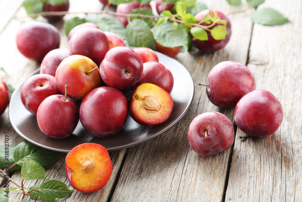 Fresh plums on a grey wooden table Fresh plums on a grey wooden table