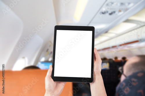 Passenger using the tablet in a plane, blank screen for copy spa