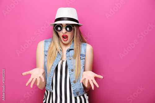 Portrait of a beautiful hipster girl on pink background
