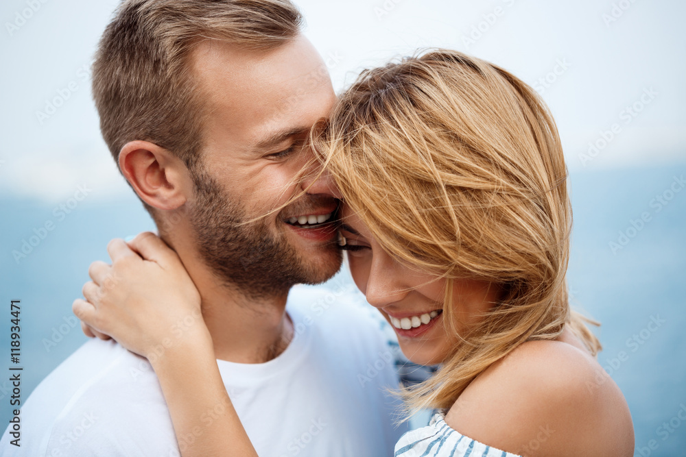Young beautiful couple smiling, rejoicing, sea background. Young beautiful couple smiling, rejoicing, sea background.