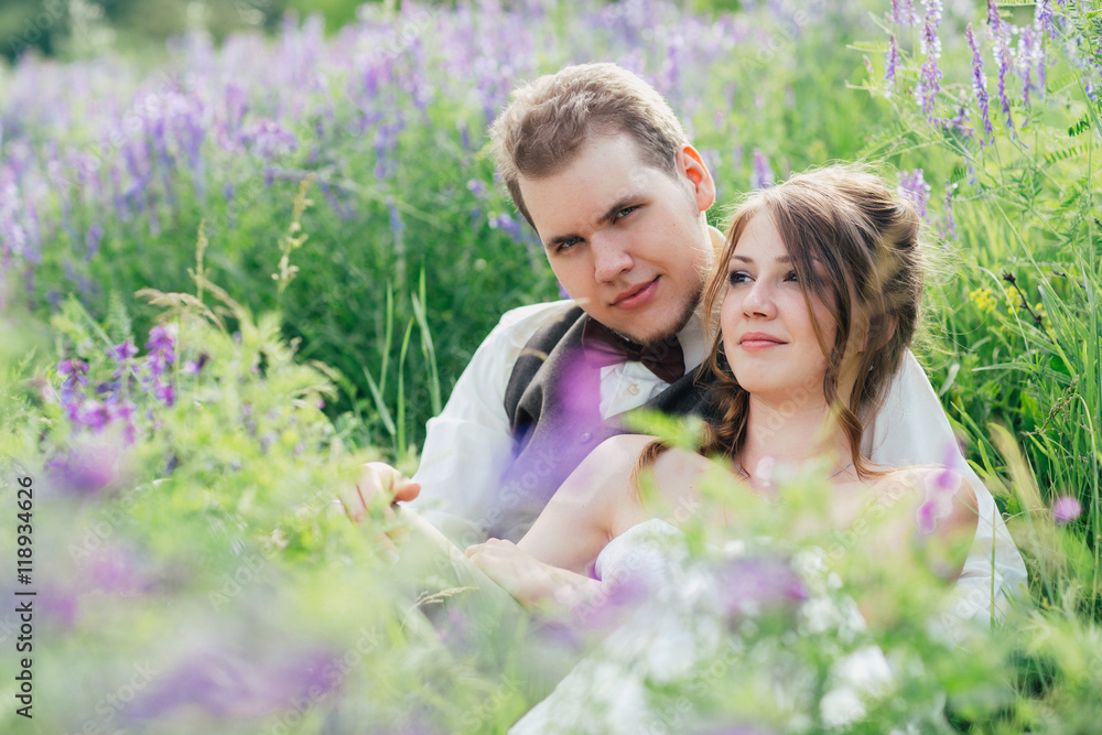 portrait of the bride and groom resting on a lavender background portrait of the bride and groom resting on a lavender background