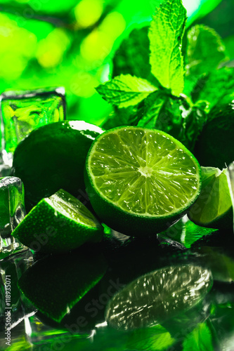 fresh green mint and lime ice cube close-up on a dark background