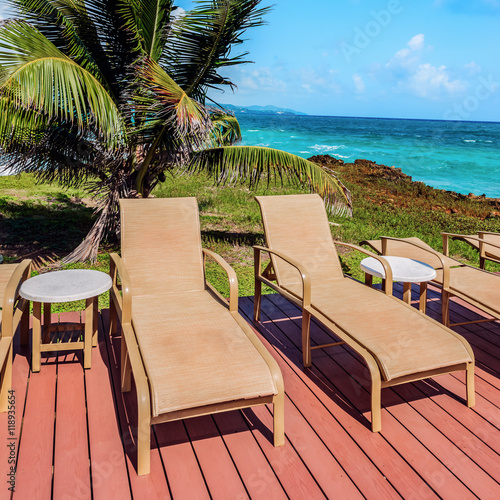 Fototapeta Naklejka Na Ścianę i Meble -  Loungers on the deck by the seafront Tobago Caribbean square composition idylic relaxing setting nature paradise sunny hot weather