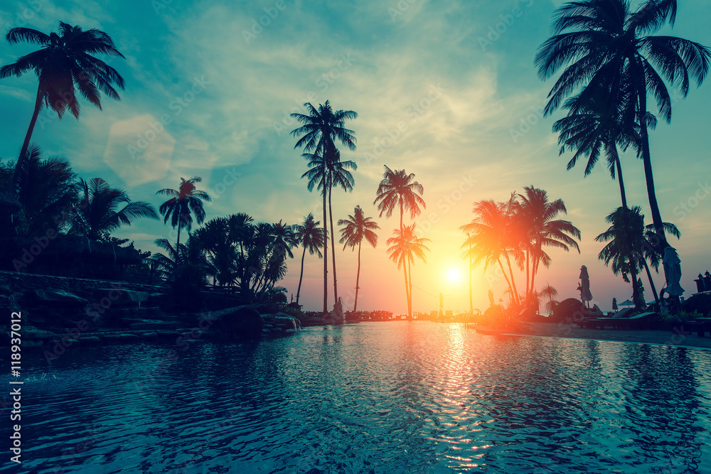 Naklejka premium Fantastyczny zachód słońca, palmy na tropikalnej plaży.