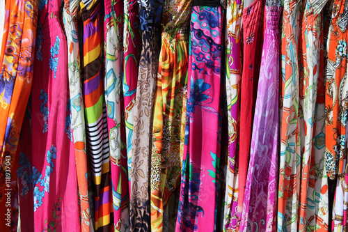 Rack of colorful dresses at an outdoor flea market