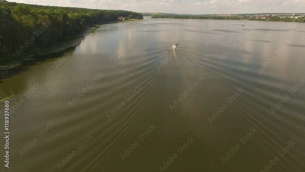 Aerial view of the cutter moving on the river, bach and houses in 4K Aerial view of the cutter moving on the river, bach and houses in 4K