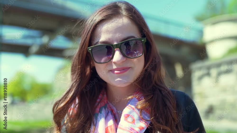 Pretty girl taking off sunglasses and smiling to the camera
Pretty girl taking off sunglasses and smiling to the camera