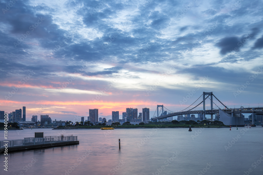 cityscape and skyline of tokyo from water at sunset