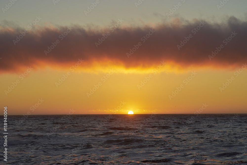 ocean at sunset with strip cloud above ocean at sunset with strip cloud above