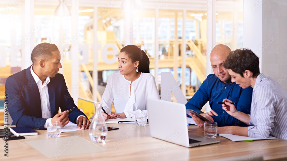Obraz premium Group of business executives meeting with each other at sunrise early in the morning in their bright, modern conference room
