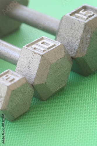5, 10, and 15 lb hand weights in a row
Vertical orientation photograph of 5, 10, and 15 lb hand weights in a row on a green mat
