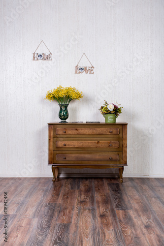 Vase with flovers on dresser in home inrerrior