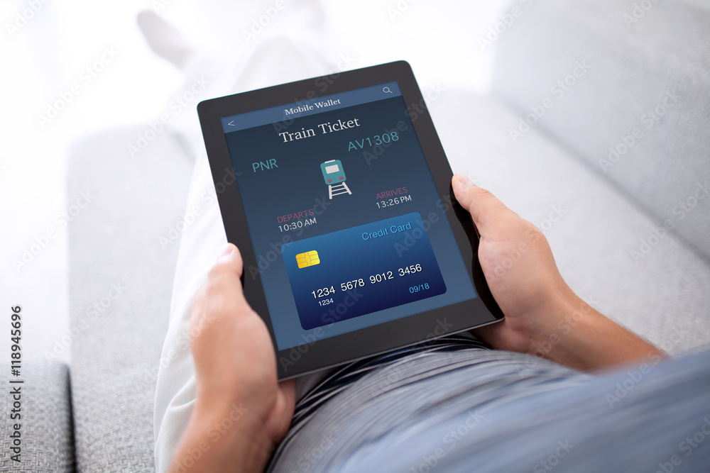 man lying sofa and holding tablet with online train ticket man lying sofa and holding tablet with online train ticket
