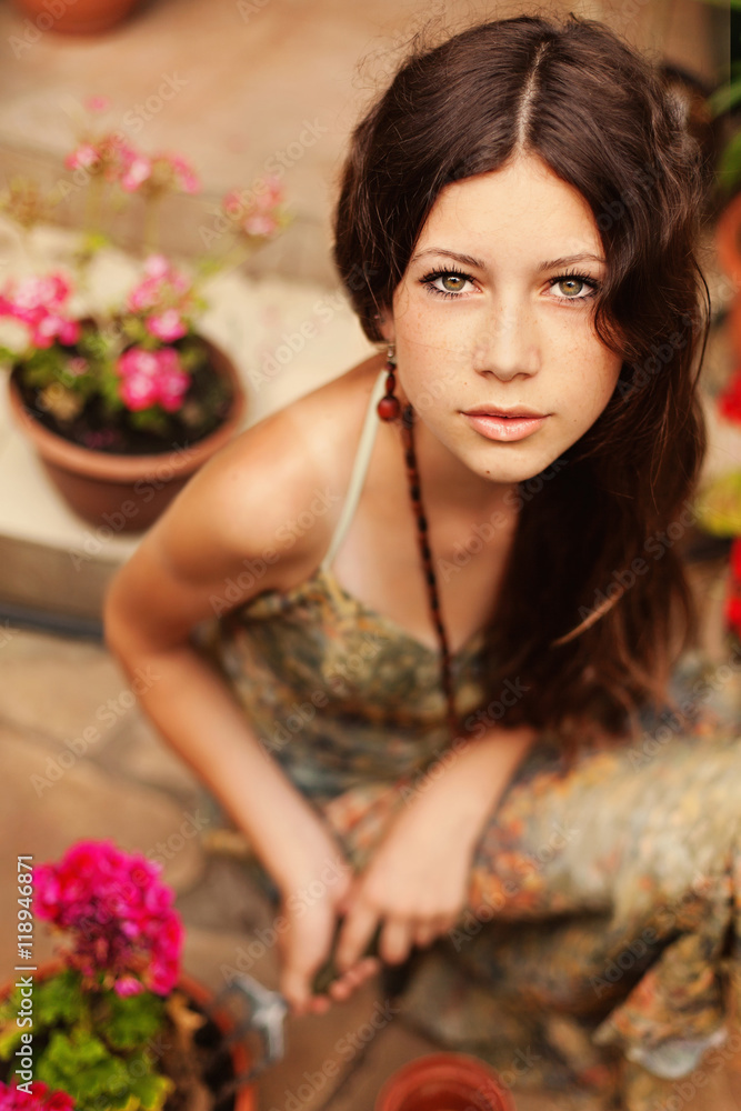 Young girl gardener with long brown hair holding a garden tool a Young girl gardener with long brown hair holding a garden tool a