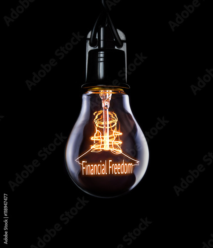 Hanging lightbulb with glowing Financial Freedom concept.