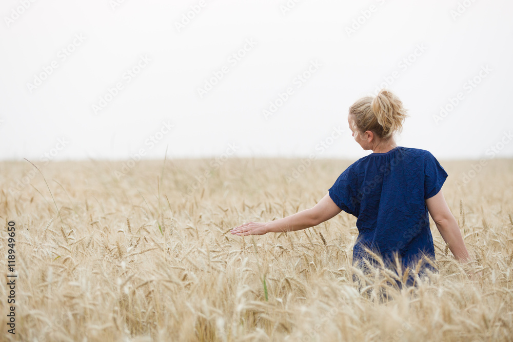 Back view on young happy woman walking on the golden wheat field on a sunny summer day. Beautiful girl outdoors raising hands in sunlight rays and running on the meadow, sun light. Back view on young happy woman walking on the golden wheat field on a sunny summer day. Beautiful girl outdoors raising hands in sunlight rays and running on the meadow, sun light.