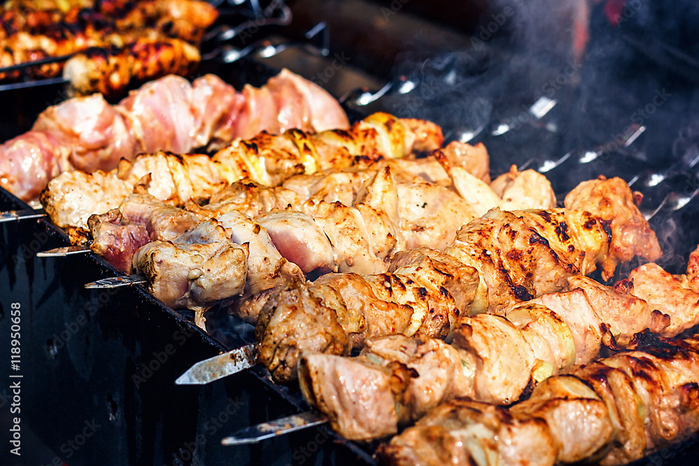 Grilling marinated shashlik preparing on a barbecue grill over charcoal.  Shashlik is a form of Shish kebab popular in Eastern Europe. Shashlyk (meaning  skewered meat) was originally made of lamb. Stock Photo