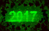 Happy new year 2017 isolated numbers written with light on black tech geometric background full of hearts