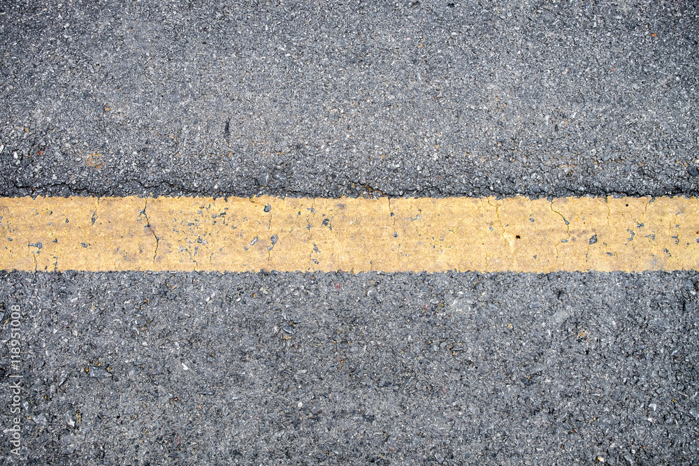 Fototapeta premium Yellow line on asphalt road texture