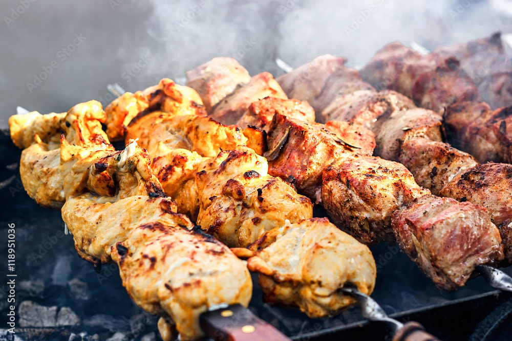 Grilling marinated shashlik preparing on a barbecue grill over charcoal.  Shashlik is a form of Shish kebab popular in Eastern Europe. Shashlyk (meaning  skewered meat) was originally made of lamb. Stock Photo