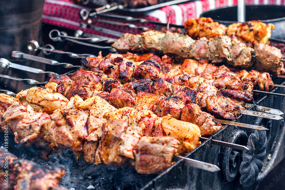 Grilling marinated shashlik preparing on a barbecue grill over charcoal.  Shashlik is a form of Shish kebab popular in Eastern Europe. Shashlyk (meaning  skewered meat) was originally made of lamb. Stock Photo