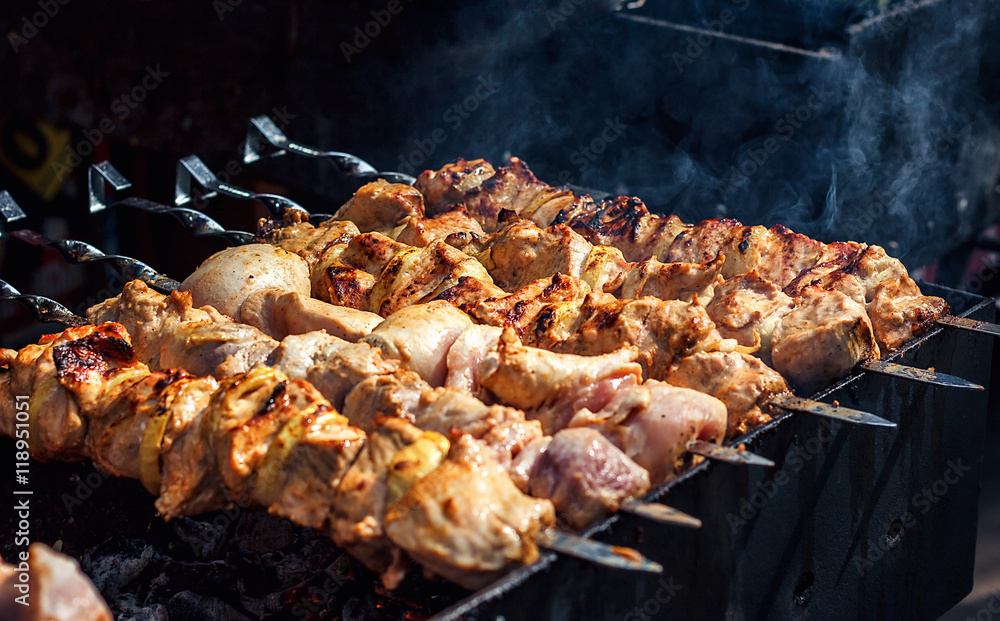 Grilling marinated shashlik preparing on a barbecue grill over charcoal.  Shashlik is a form of Shish kebab popular in Eastern Europe. Shashlyk (meaning  skewered meat) was originally made of lamb. Stock Photo