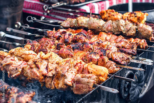 Grilling marinated shashlik preparing on a barbecue grill over charcoal. Shashlik is a form of Shish kebab popular in Eastern Europe. Shashlyk (meaning skewered meat) was originally made of lamb.
