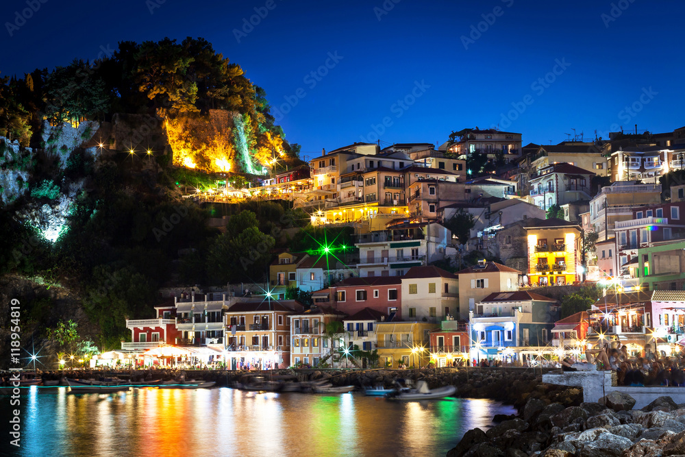 Night in Parga, Greece. A view at fortress, houses and boats near the rocky coast.