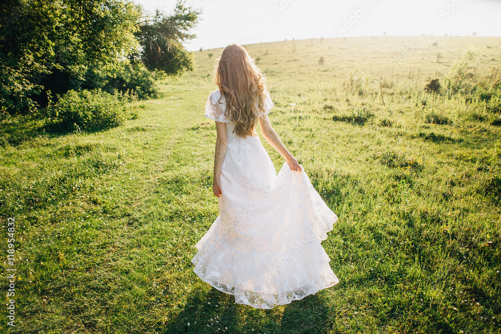 Young girl in a white dress in the meadow. Woman in a beautiful long dress posing in the garden. Stunning bride in a wedding dress Young girl in a white dress in the meadow. Woman in a beautiful long dress posing in the garden. Stunning bride in a wedding dress