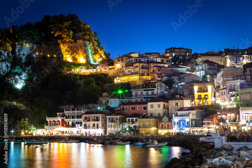 Night in Parga, Greece. A view at fortress, houses and boats near the rocky coast. photo