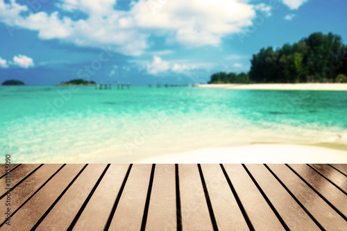 Wood table top on blurred sea beach white sand on andaman sea