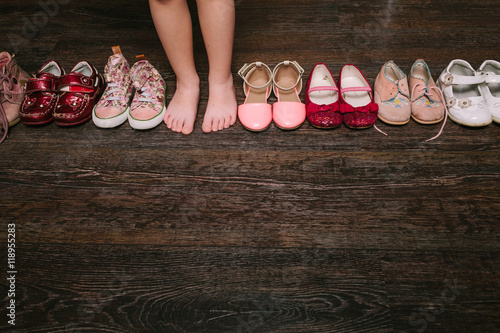 Old worn baby (child, kid) shoes on the floor. sandals, boots, s