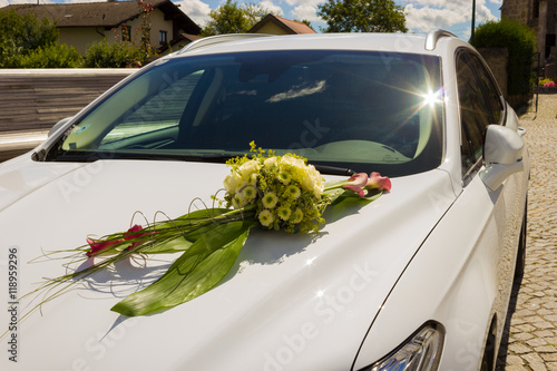 Hochzeit, weißes Auto mit Blumenschmuck.