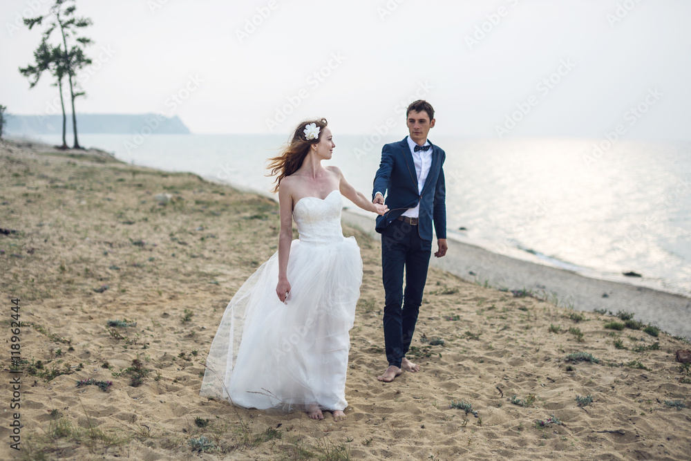 happy just married young couple celebrating at beautiful beach happy just married young couple celebrating at beautiful beach