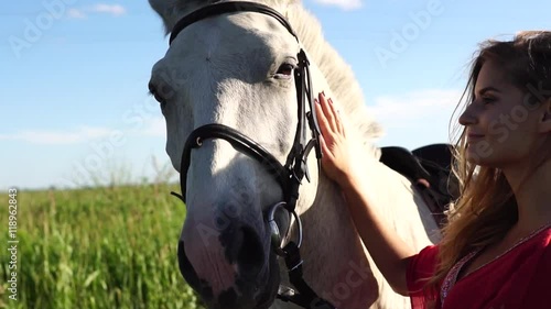 Portrait of young beautiful woman dreesed in red with white horse near the field HD photo