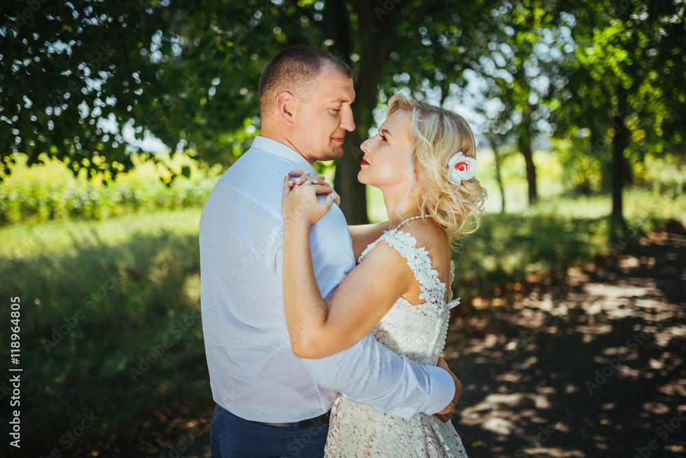 Fototapeta premium Bride and groom at wedding day, walking outdoor at summer on nature. Bridal couple, happy newlywed woman and man embracing. Loving wedding couple outdoor. 