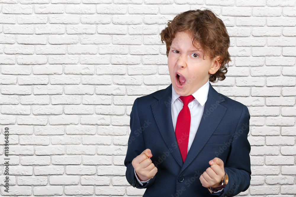 Angry curly boy in a formal suit Angry curly boy in a formal suit