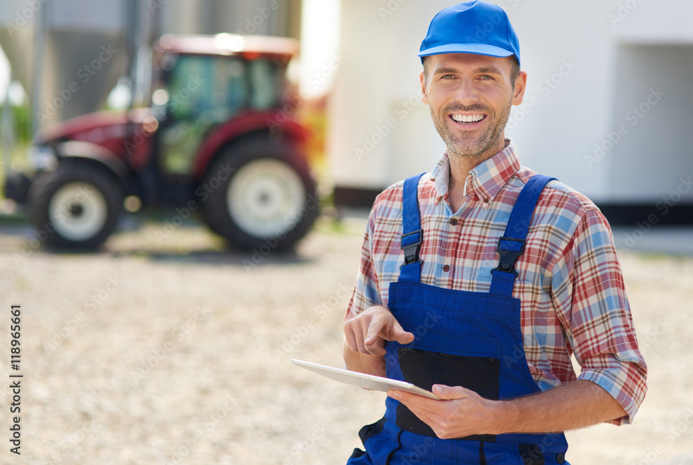 Obraz premium Young farmer using digital tablet.