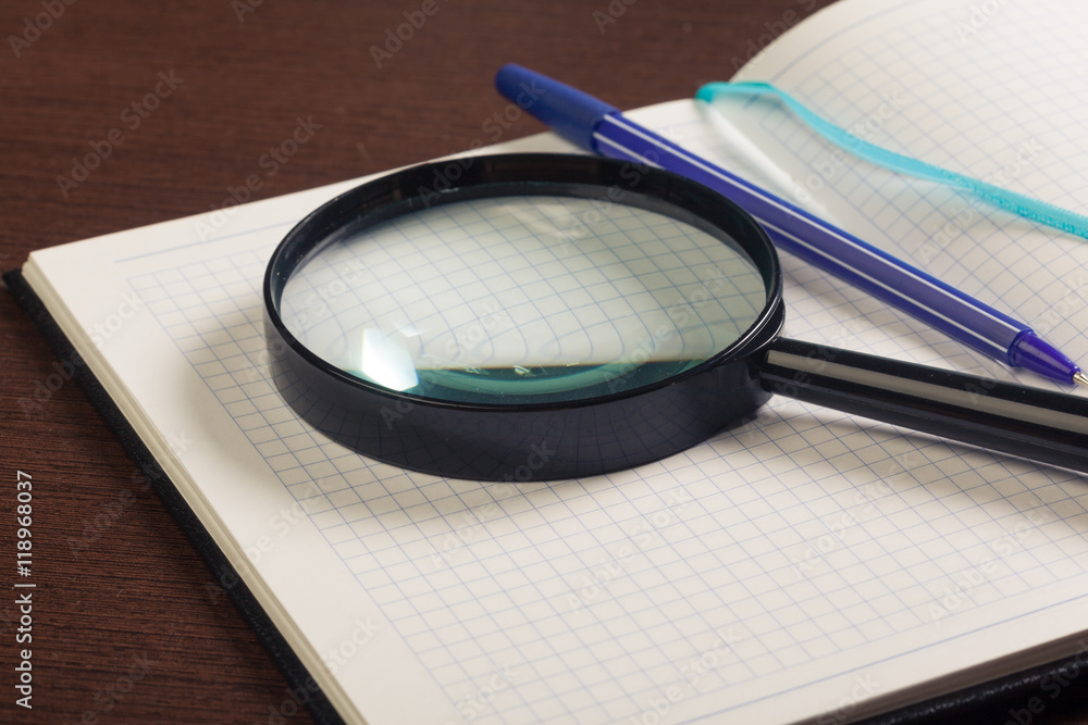 Magnifying glass and book o the wooden background Magnifying glass and book o the wooden background