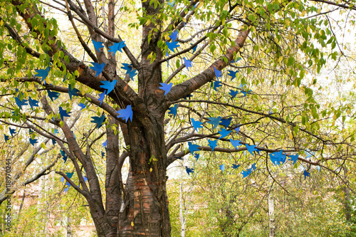 Blue birds of paper hanging on tree
