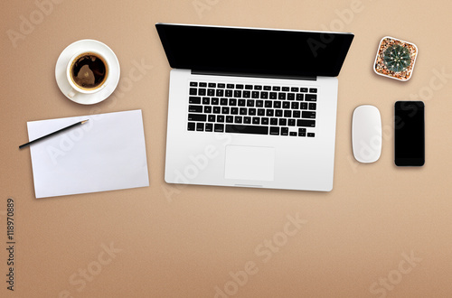 workplace with blank screen smartphone, tablet, coffee cup, paper and notebook on wooden table. top view with copy space. over light