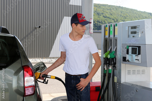 Young man putting fuel car photo