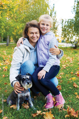 Portrait of smiling woman with cute little girl in autumn park
